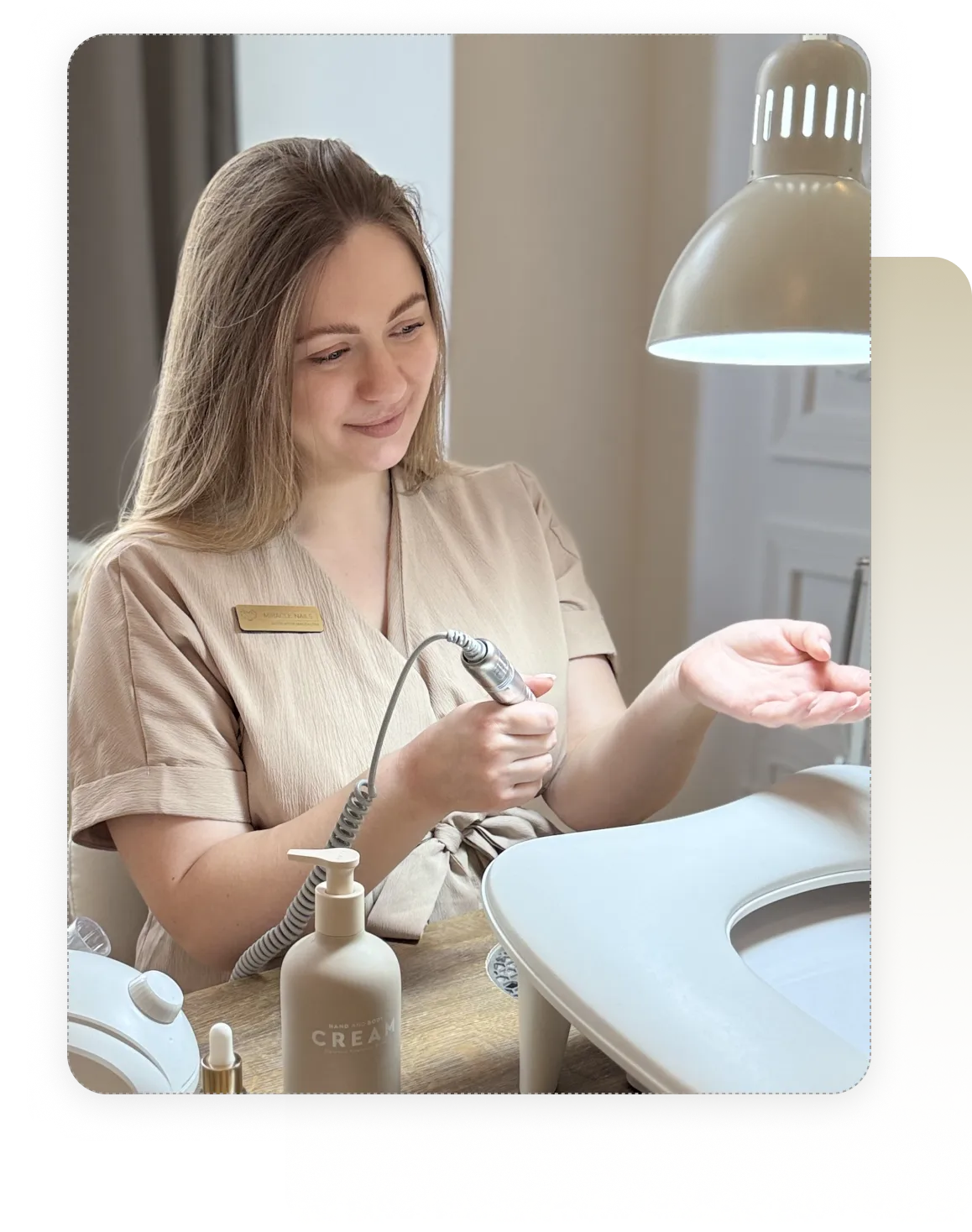 Uśmiechnięta właścicielka salonu beauty trzymająca telefon z aplikacją Estetify.